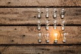 Background. Glowing bulb uniqueness concept on brown wooden