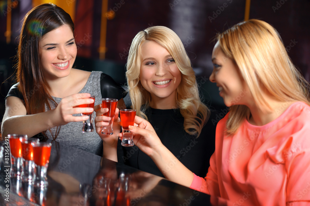 Three women have a drink in the bar Three women have a drink in the bar