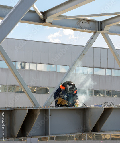welder welds the steel bridge construction