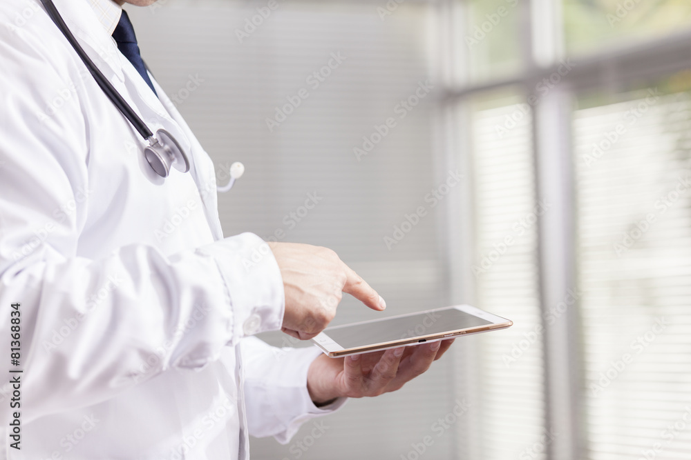 Doctor holding a digital tablet at his office Doctor holding a digital tablet at his office