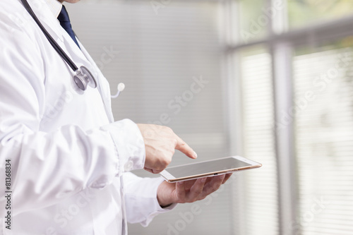 Doctor holding a digital tablet at his office