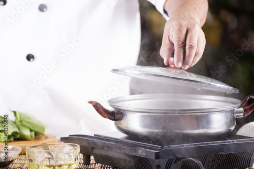 Chef opening the lid of pot before cooking noodle