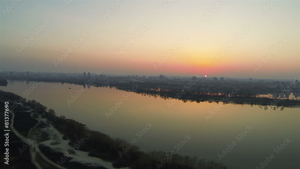 Flight over river with city on red sunset. Aerial shot Flight over river with city on red sunset. Aerial shot