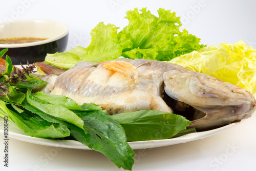 Steamed Fish with vegetables and sauce on white background