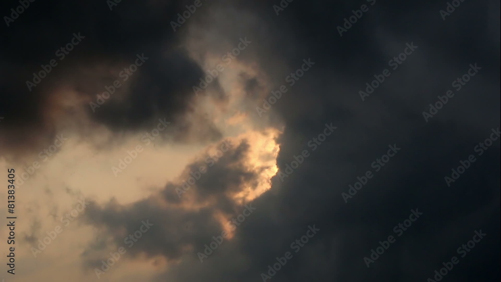 Cloudscape with sun shining behind dark storm clouds Cloudscape with sun shining behind dark storm clouds
