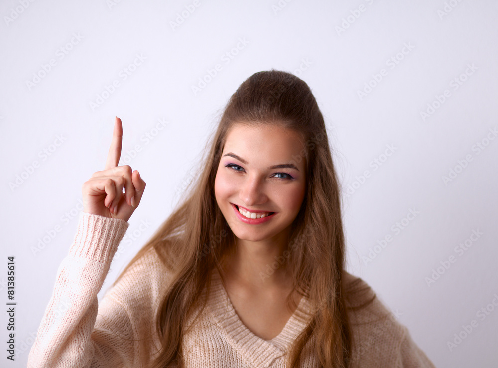 Portrait of a smiling young woman pointing up Portrait of a smiling young woman pointing up