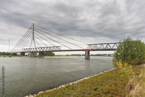 Deconstruction of an old bridge next to a new suspension bridge