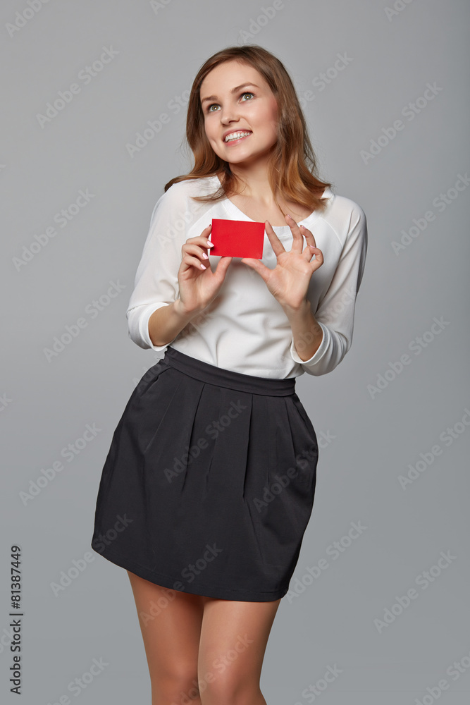 Happy business woman showing blank credit card, over gray backgr Happy business woman showing blank credit card, over gray backgr
