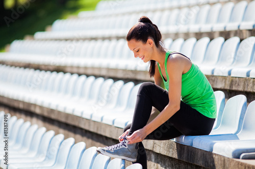 Young woman tying a shoelace before jogging
