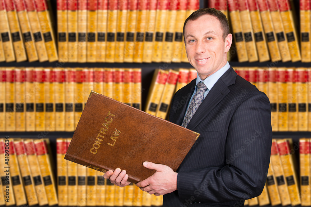 Young Lawyer with law books in the background Stock Photo | Adobe Stock