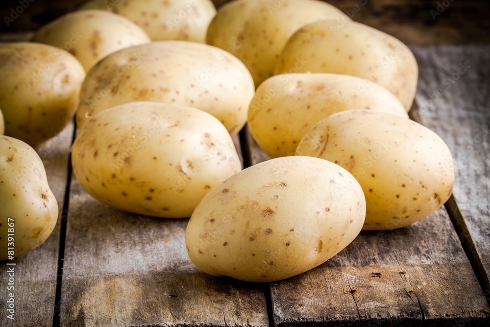 Fresh organic raw potatoes on the old table Fresh organic raw potatoes on the old table