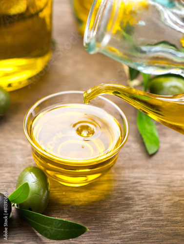 Virgin olive oil pouring in a bowl closeup. Dieting concept