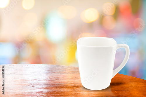 Coffee cup on wood table at blur bokeh background