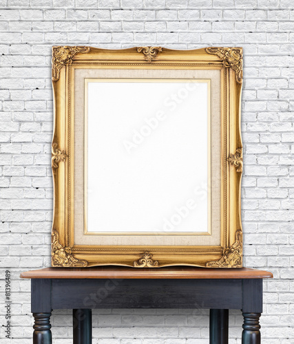 Blank vintage golden photo frame lean at white brick wall on woo