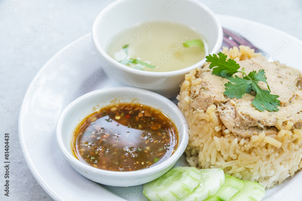 Rice roast chicken with spoon and fork on white plate.