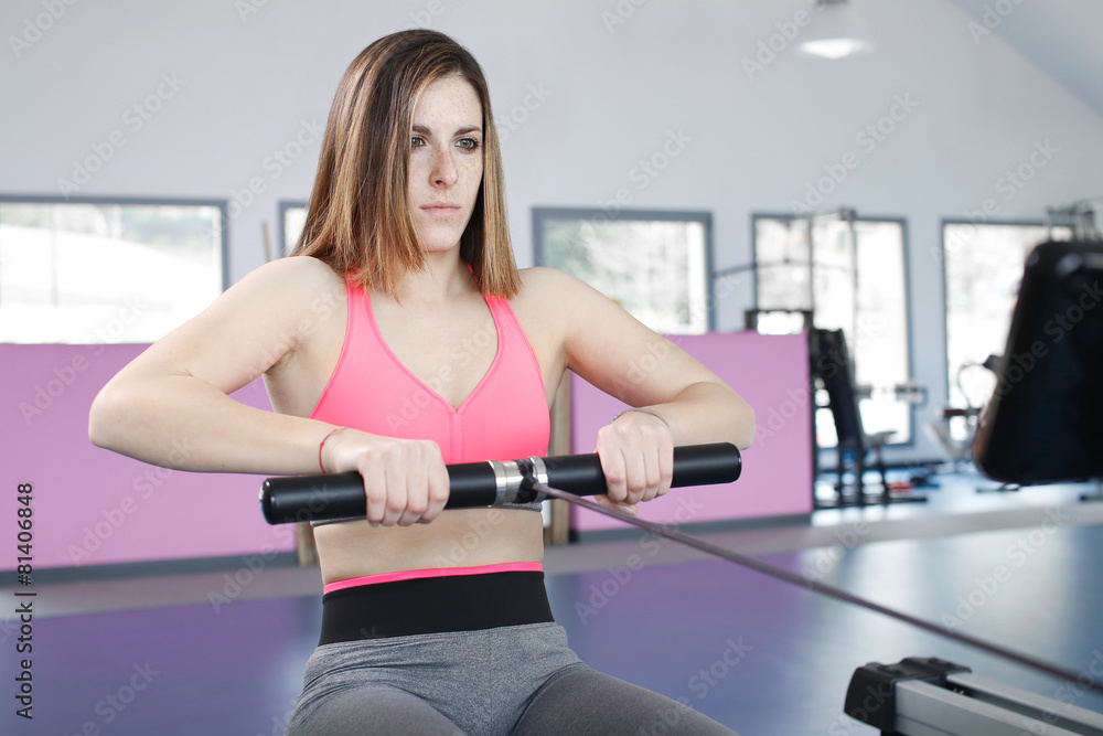 Fototapeta premium young woman exercising at the gym doing some pulls