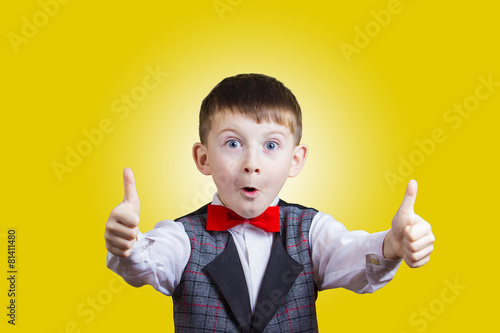 Excited Surprised little boy with thumb up gesture photo