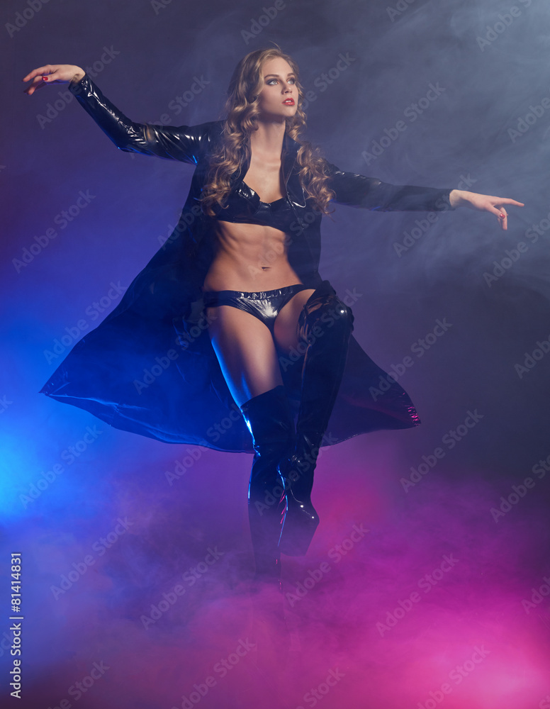 Fantastic female dancer in glow of purple smoke