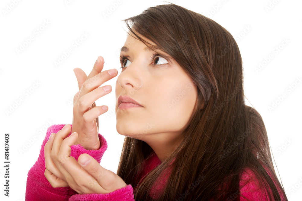 Woman putting contact lens in her eye. Woman putting contact lens in her eye.