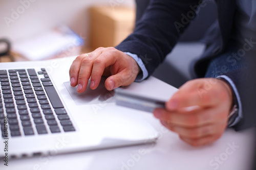 Businessman using his credit card for an online transaction