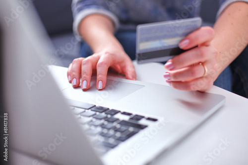 Woman sitting at the desk, shopping with laptop and credit card © lenetsnikolai