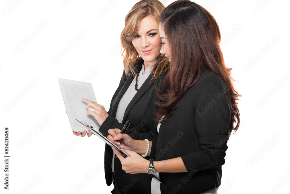 Two young businesswoman discuss with a clipboard, isolated Two young businesswoman discuss with a clipboard, isolated