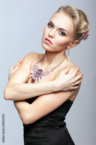 Blonde woman in black dress and necklace