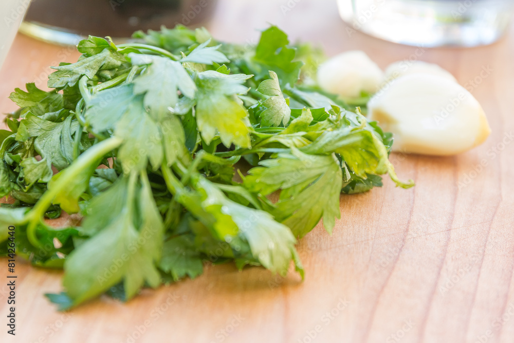 parsley and garlic on wooden cutting board, cooking time backgro parsley and garlic on wooden cutting board, cooking time backgro