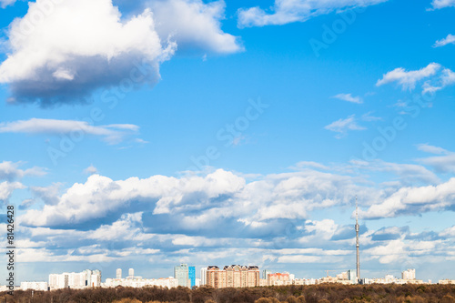 white clouds in blue spring sky over city © vvoe