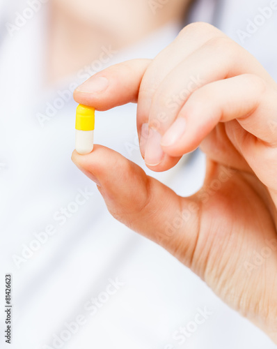nurse holds pilule in finger