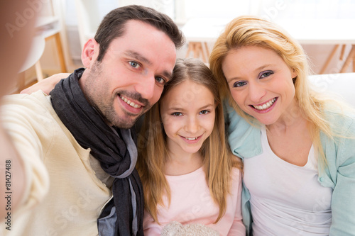 Happy family in a sofa taking selfie