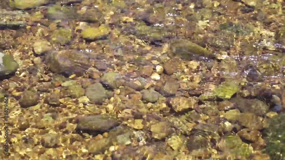 waterfall are flowing through a rock in the shallow water area waterfall are flowing through a rock in the shallow water area