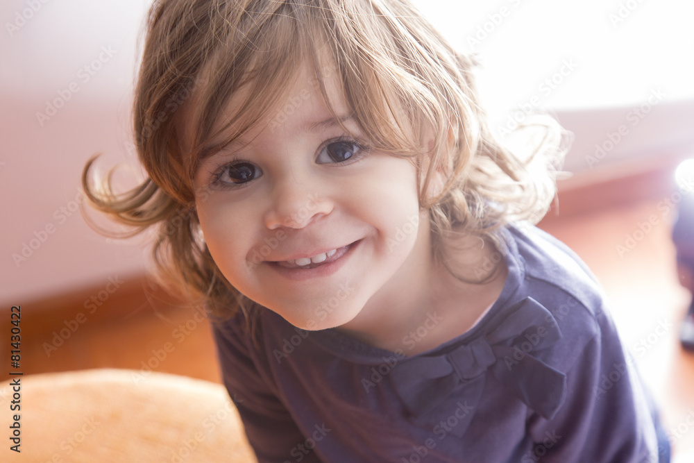 Adorable little girl looking at camera at home Adorable little girl looking at camera at home