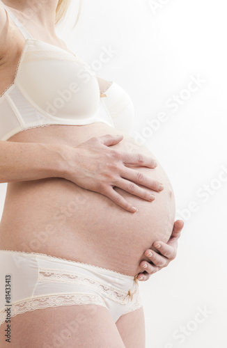 close up of standing pregnant woman wearing lingerie