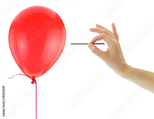 Nail about to pop a balloon isolated on white