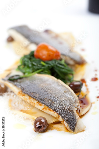 Fischfilet von Wolfsbarsch mit Ravioli, Oliven, Gemüse photo