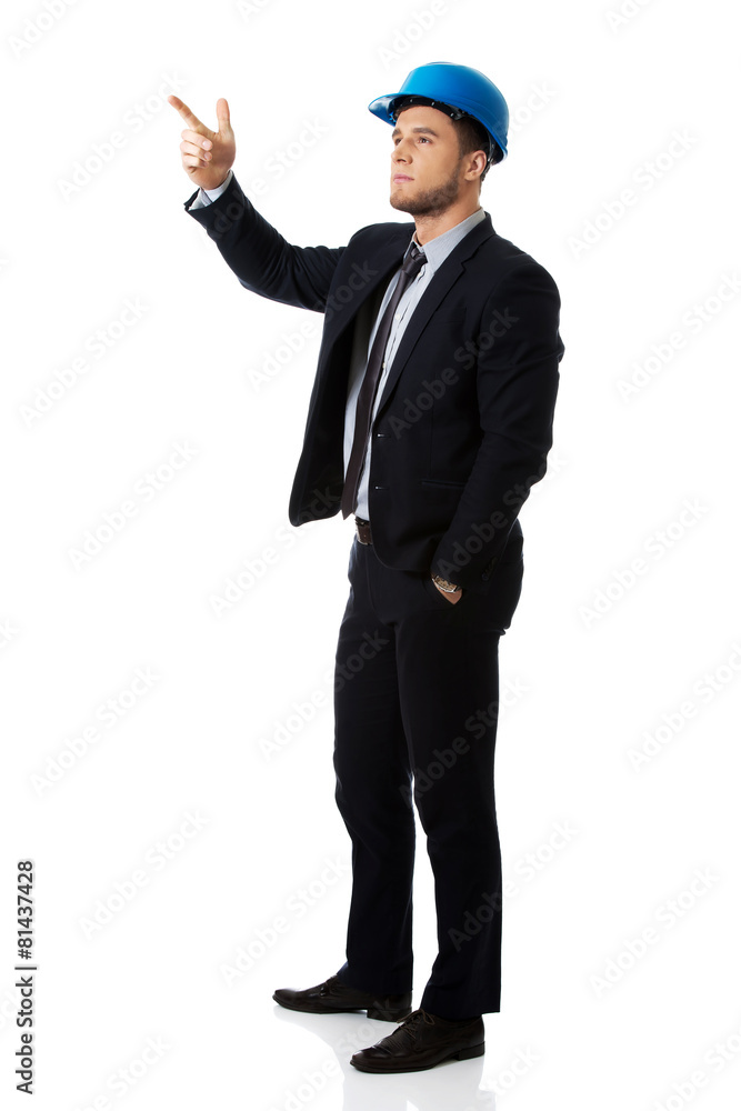 Happy businessman in helmet points his finger up. Happy businessman in helmet points his finger up.