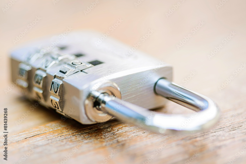 Combination padlock close up with chrome numbers on wooden backg Combination padlock close up with chrome numbers on wooden backg