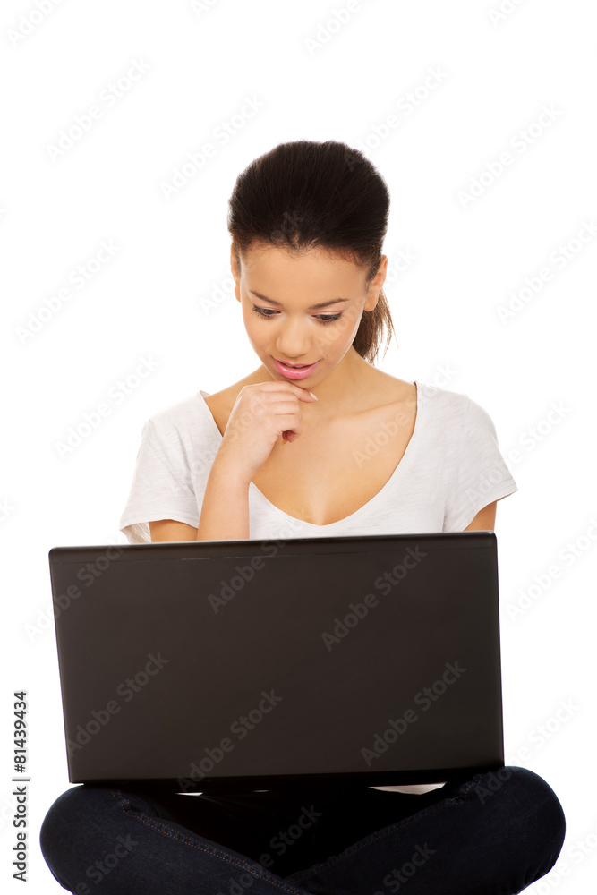 Teen sitting cross legged with laptop. Teen sitting cross legged with laptop.