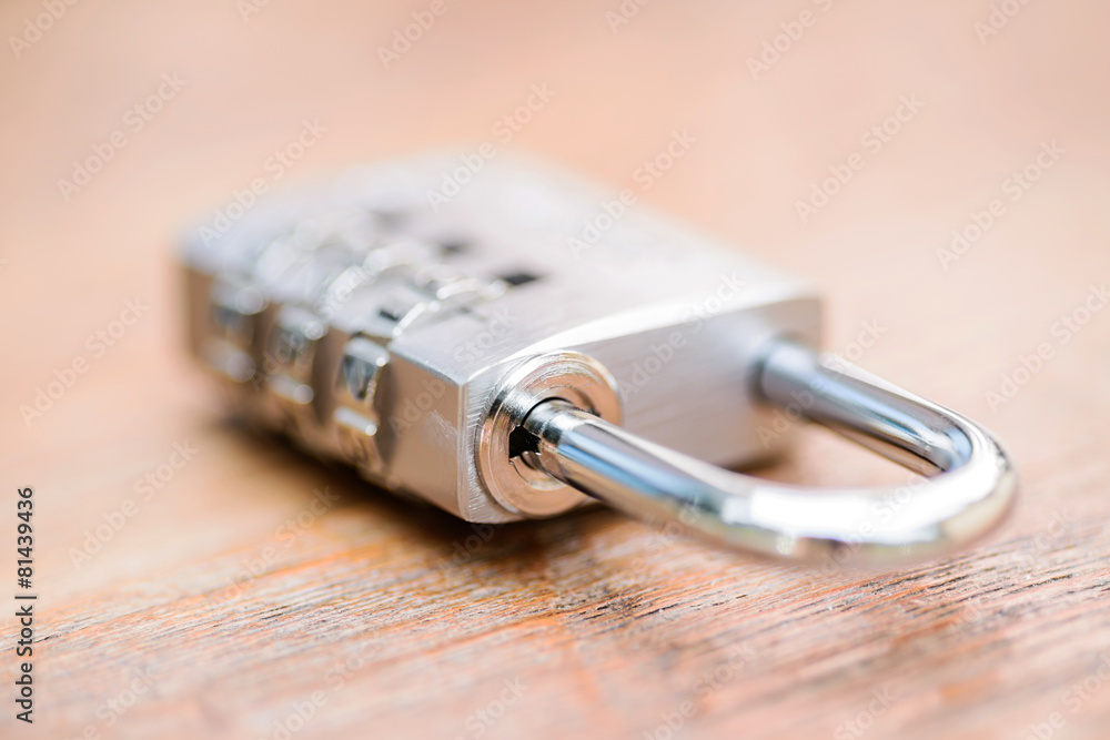 Combination padlock close up with chrome numbers on wooden backg Combination padlock close up with chrome numbers on wooden backg
