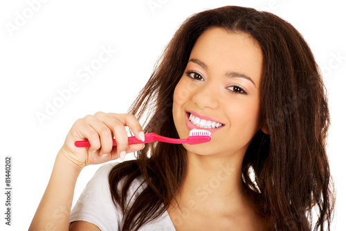 Beautiful teen brushing her teeth.