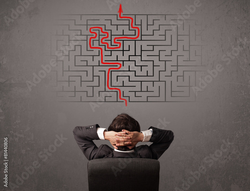 Business man looking at a maze and the way out