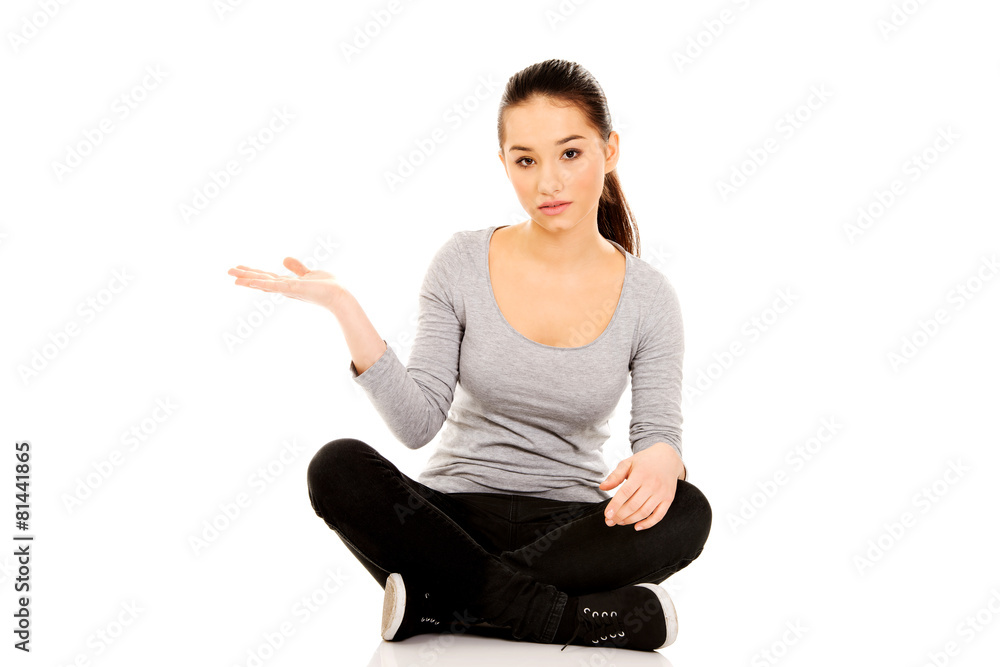 Woman sitting cross legged with open hand. Woman sitting cross legged with open hand.