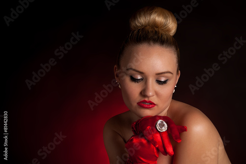 Attraktive Frau in roten Handschuhen und einem großen Ring