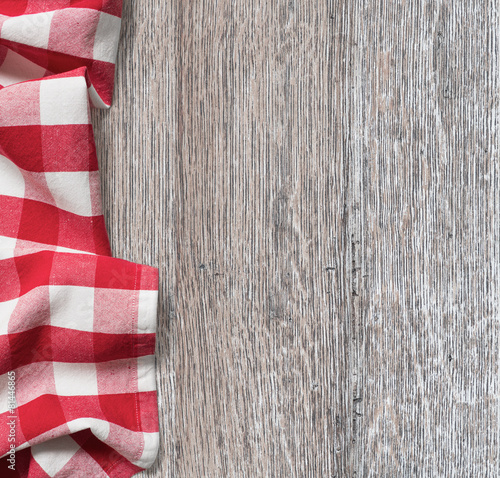 rough wood kitchen table with red picnic cloth background