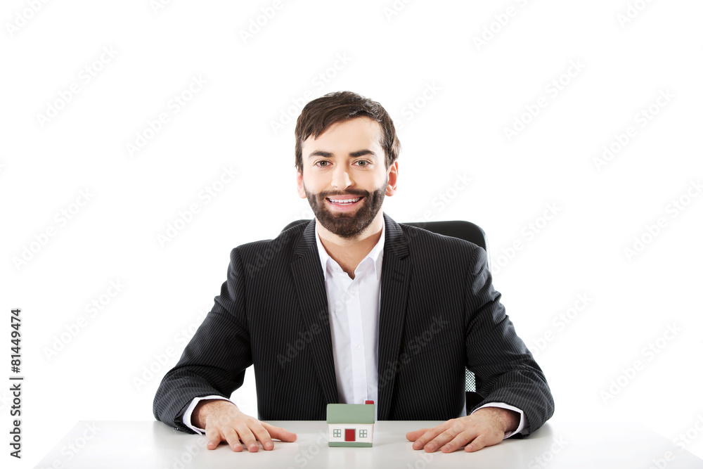 Businessman with a mini house in the office. Businessman with a mini house in the office.