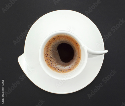 white cup of organic coffee on the background of black paper