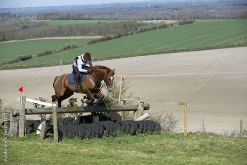 Horse rider jumping a fence English countryside photo