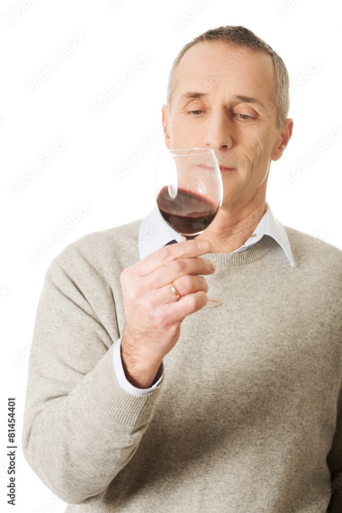 Mature man tasting red wine