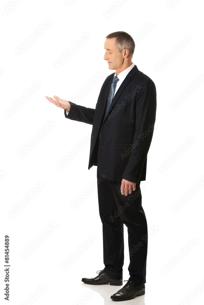 Businessman holding something on his palm Businessman holding something on his palm